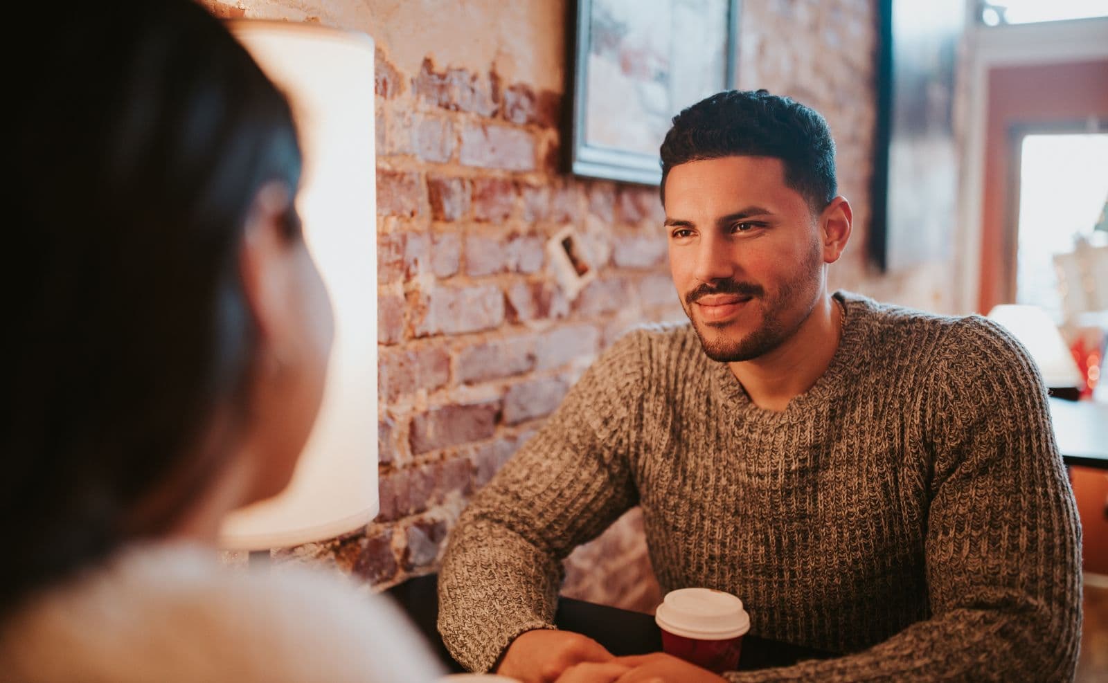 A casual couple sharing coffee together at a low-key café table