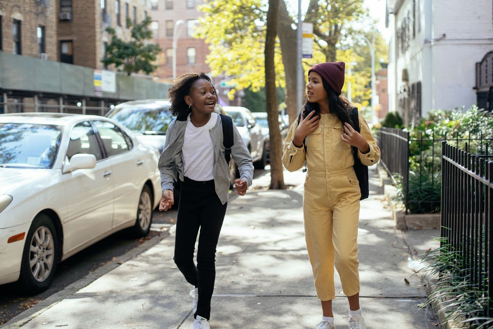 Two friends walking and talking together on a city sidewalk