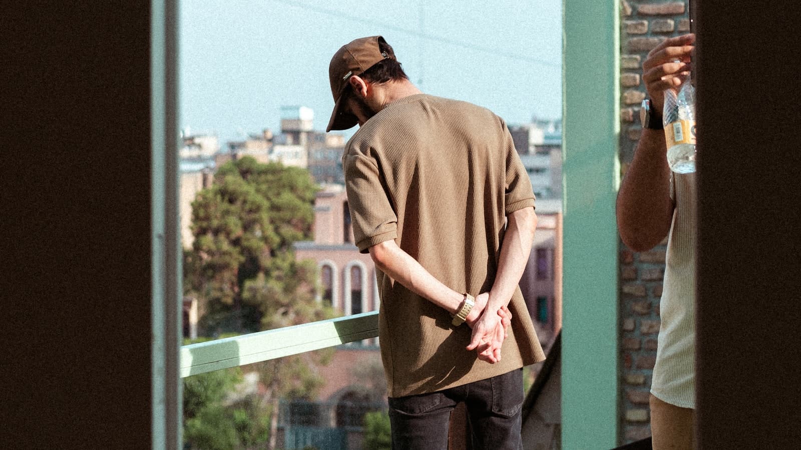 A solo traveler looking out over a city skyline from a balcony